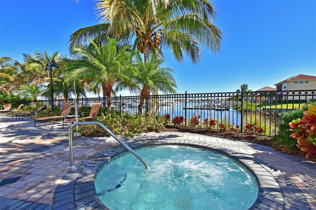 615 Riviera Dunes Way, Unit 107 Palmetto, FL 34221 - Photo 47 of 50 a view of a swimming pool with a lounge chair and palm trees