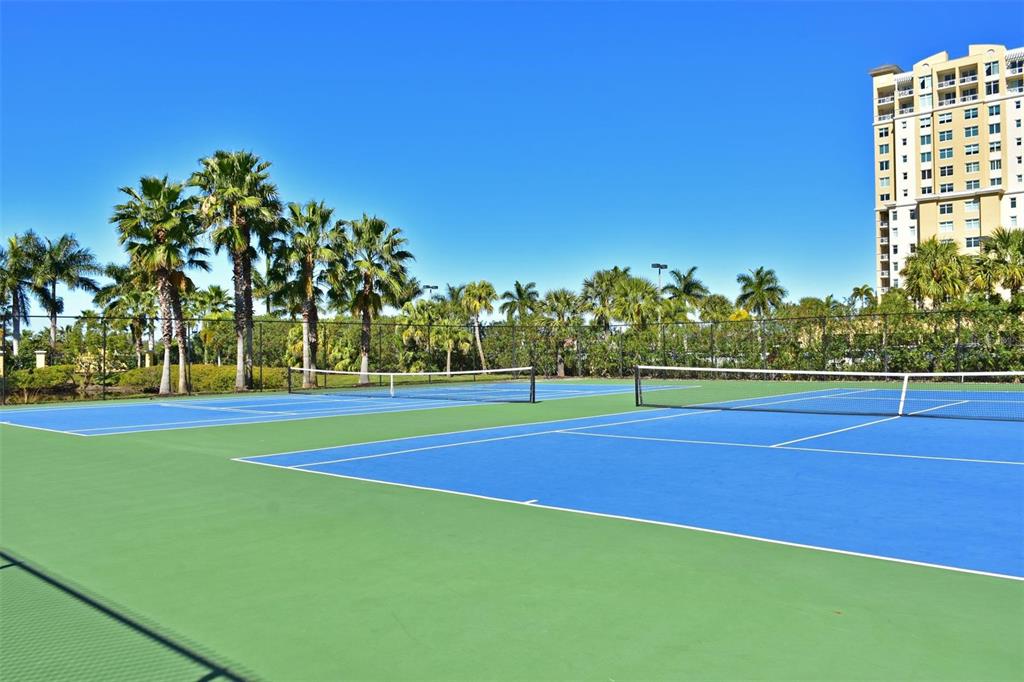615 Riviera Dunes Way, Unit 107 Palmetto, FL 34221 - Photo 48 of 50 a view of a tennis ground with large trees