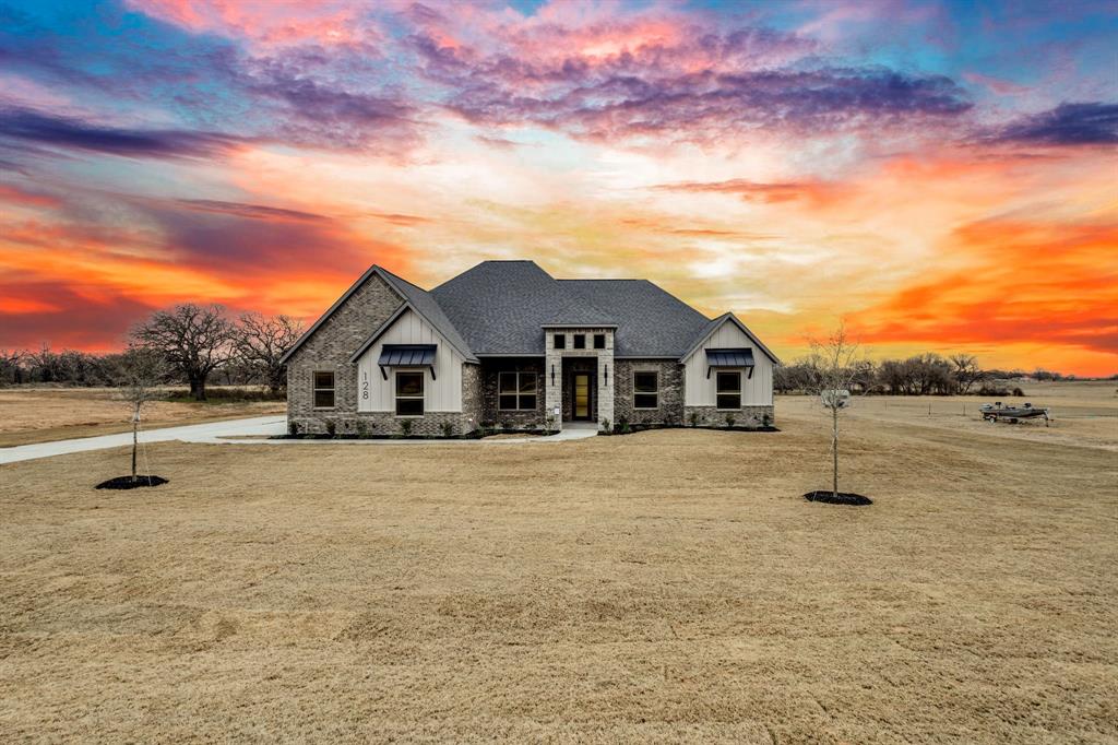 128 Prairie Winds Drive Poolville, TX 76487 - Photo 1 of 40 a front view of a house with a yard