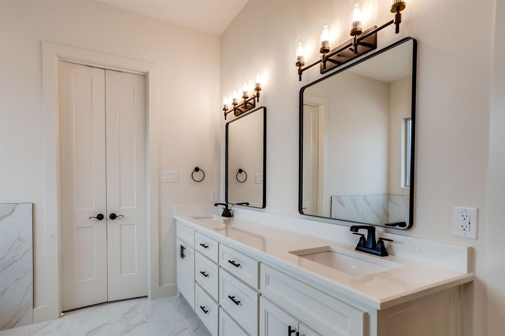 128 Prairie Winds Drive Poolville, TX 76487 - Photo 18 of 40 a bathroom with a sink double vanity and a mirror