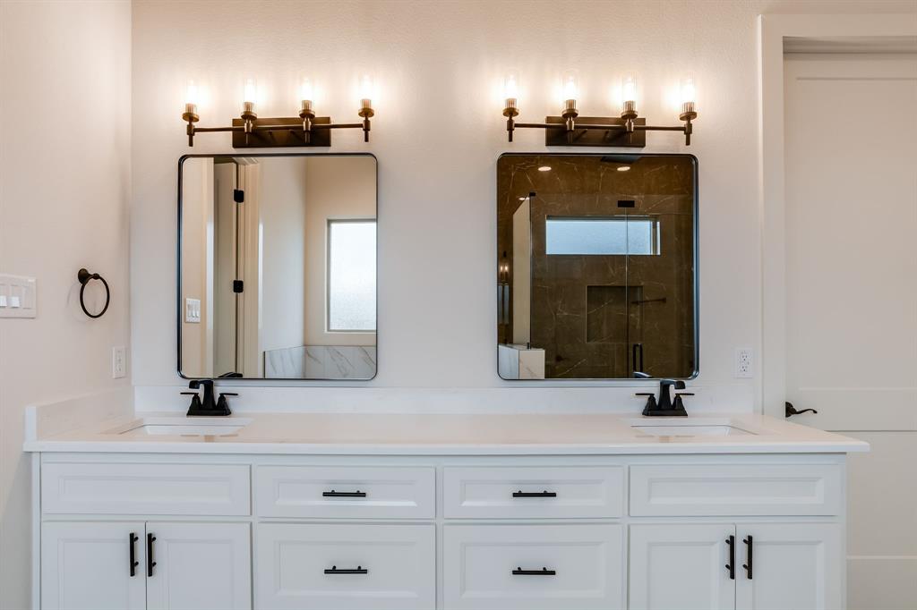 128 Prairie Winds Drive Poolville, TX 76487 - Photo 19 of 40 a bathroom with double vanity and a mirror