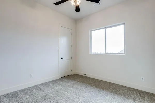 an empty room with chandelier fan