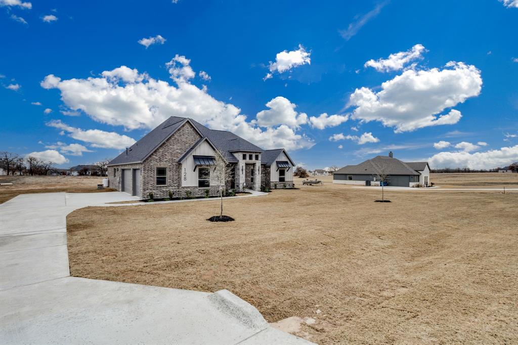 128 Prairie Winds Drive Poolville, TX 76487 - Photo 3 of 40 a view of a house with a yard