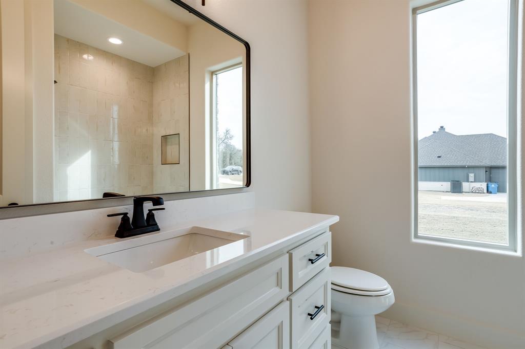 128 Prairie Winds Drive Poolville, TX 76487 - Photo 34 of 40 a bathroom with a sink a toilet a window and mirror