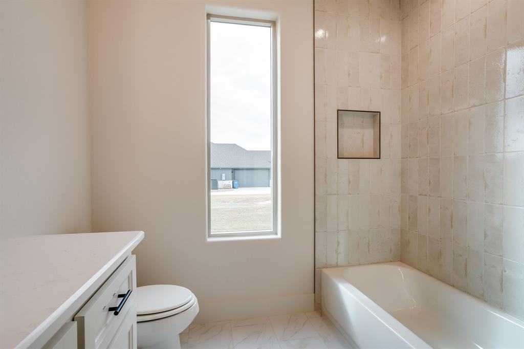 128 Prairie Winds Drive Poolville, TX 76487 - Photo 35 of 40 a bathroom with a bathtub a toilet a sink and a shower