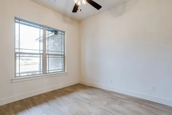 an empty room with wooden floor and cabinet