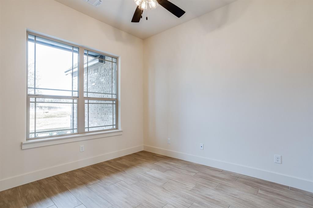 128 Prairie Winds Drive Poolville, TX 76487 - Photo 36 of 40 an empty room with a window and wooden floor