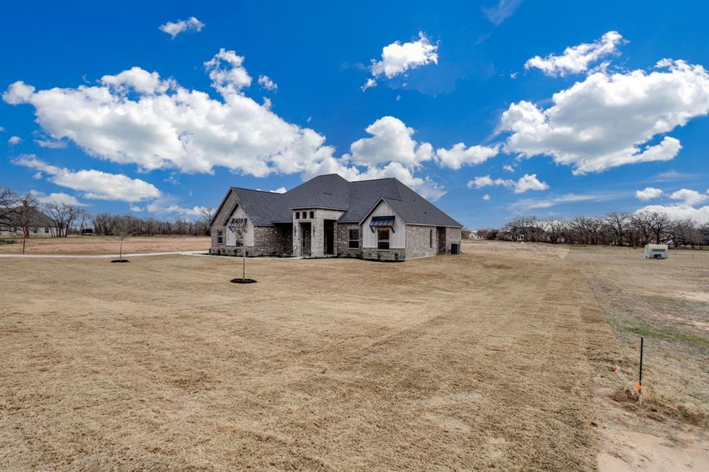 128 Prairie Winds Drive Poolville, TX 76487 - Photo 5 of 40 a view of a house with a yard