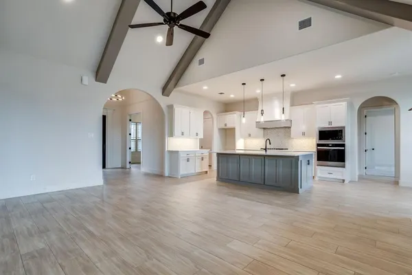 a large kitchen with stainless steel appliances kitchen island granite countertop a stove a refrigerator a sink and a cabinets