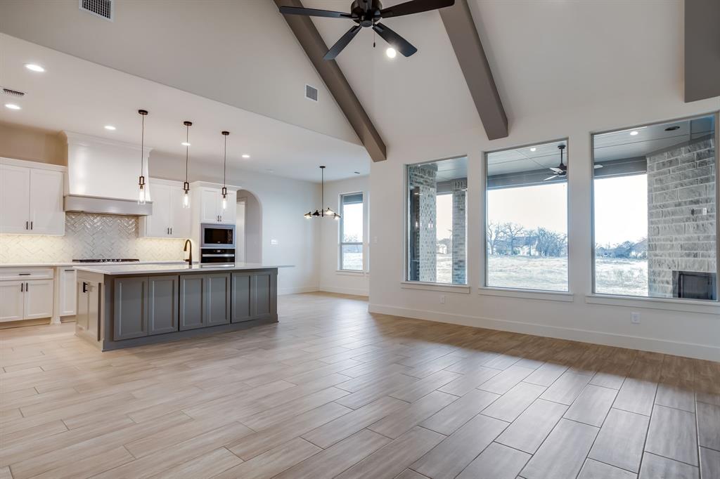 128 Prairie Winds Drive Poolville, TX 76487 - Photo 9 of 40 a large kitchen with stainless steel appliances granite countertop a large counter top a stove and a wooden floors