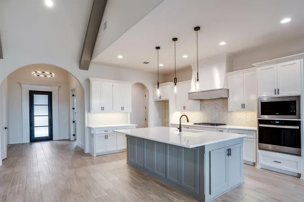 a kitchen with kitchen island a sink stainless steel appliances and cabinets