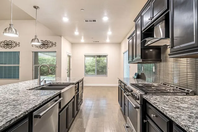 a kitchen with granite countertop stainless steel appliances window a sink and a counter
