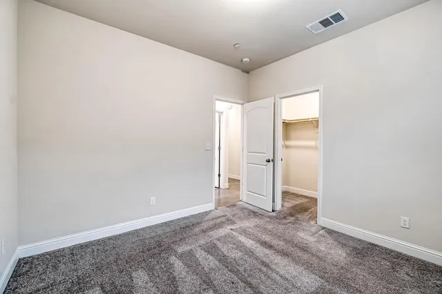 an empty room with closet and wooden floor