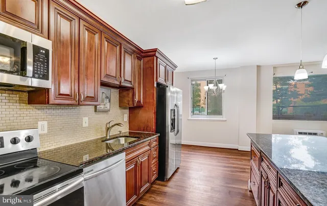 a kitchen with stainless steel appliances granite countertop a sink stove and microwave