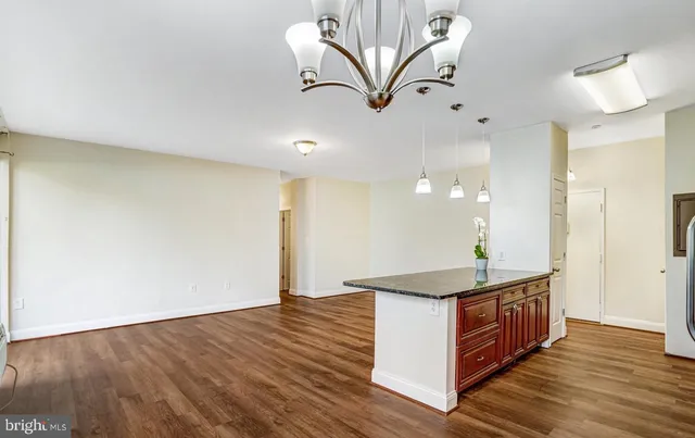 a view of a hallway with wooden floor and a living room