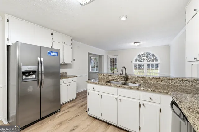 a kitchen with stainless steel appliances granite countertop a refrigerator and a sink