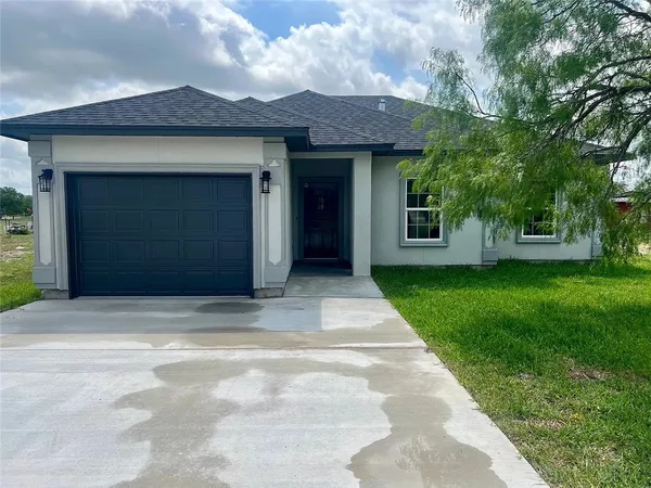 a front view of a house with a garden and yard