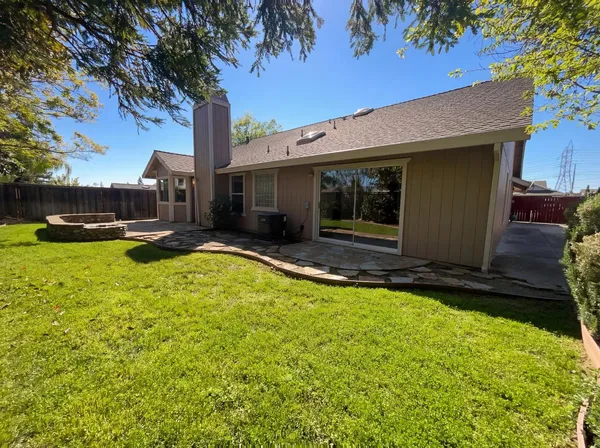 a view of a house with backyard and sitting area