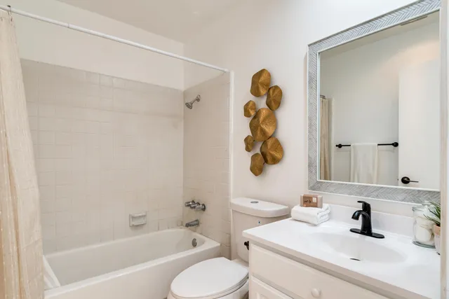 a bathroom with a sink mirror vanity and toilet
