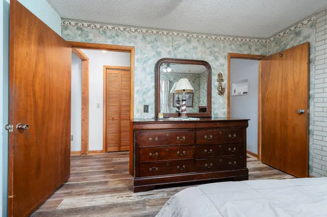 a bedroom with a bed and a flat tv screen on dresser