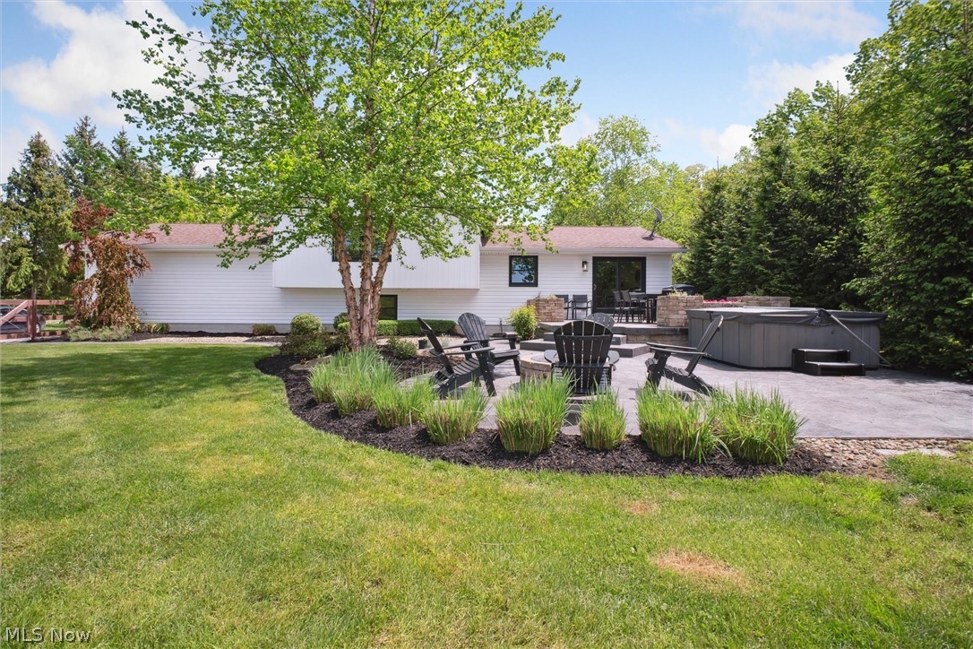 2035 Porter Road Atwater, OH 44201 - Photo 39 of 50 View of back of house featuring a hot tub, a patio, and a lawn