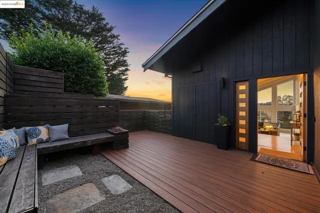 a backyard of a house with wooden floor and outdoor seating
