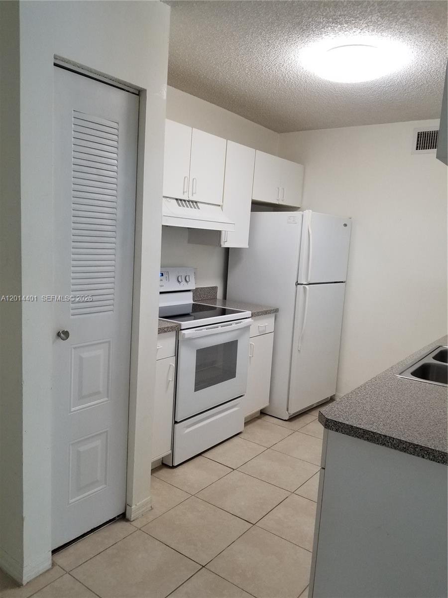 470 South Park Road, Unit 7110 Hollywood, FL 33021 - Photo 4 of 18 a kitchen with white cabinets and white appliances