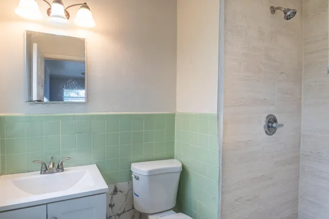 a bathroom with a toilet sink and mirror
