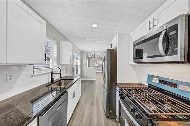 a kitchen with stainless steel appliances granite countertop a stove and a sink