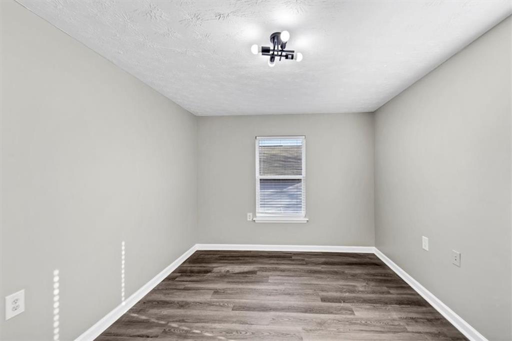 2478 Verbena Circle Northwest Atlanta, GA 30314 - Photo 25 of 42 a view of an empty room with a window and wooden floor