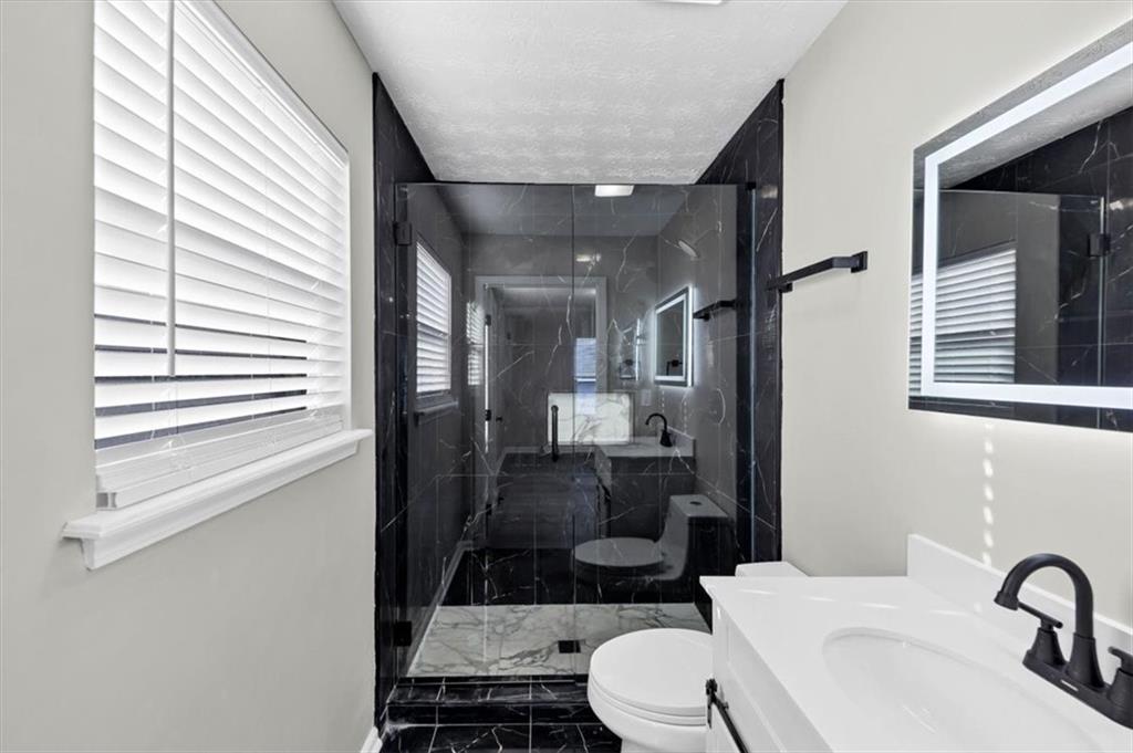 2478 Verbena Circle Northwest Atlanta, GA 30314 - Photo 29 of 42 a bathroom with a sink a toilet a mirror and shower