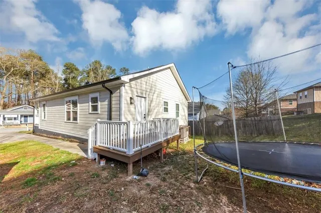 a view of a house with a wooden deck and a yard