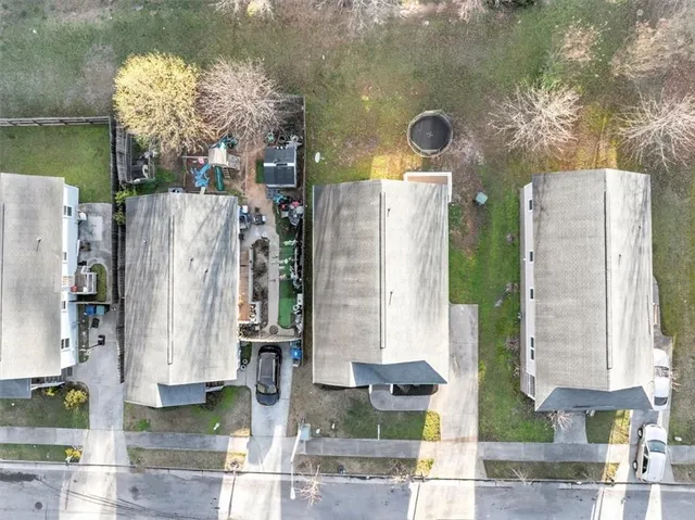 an aerial view of residential houses with outdoor space and parking
