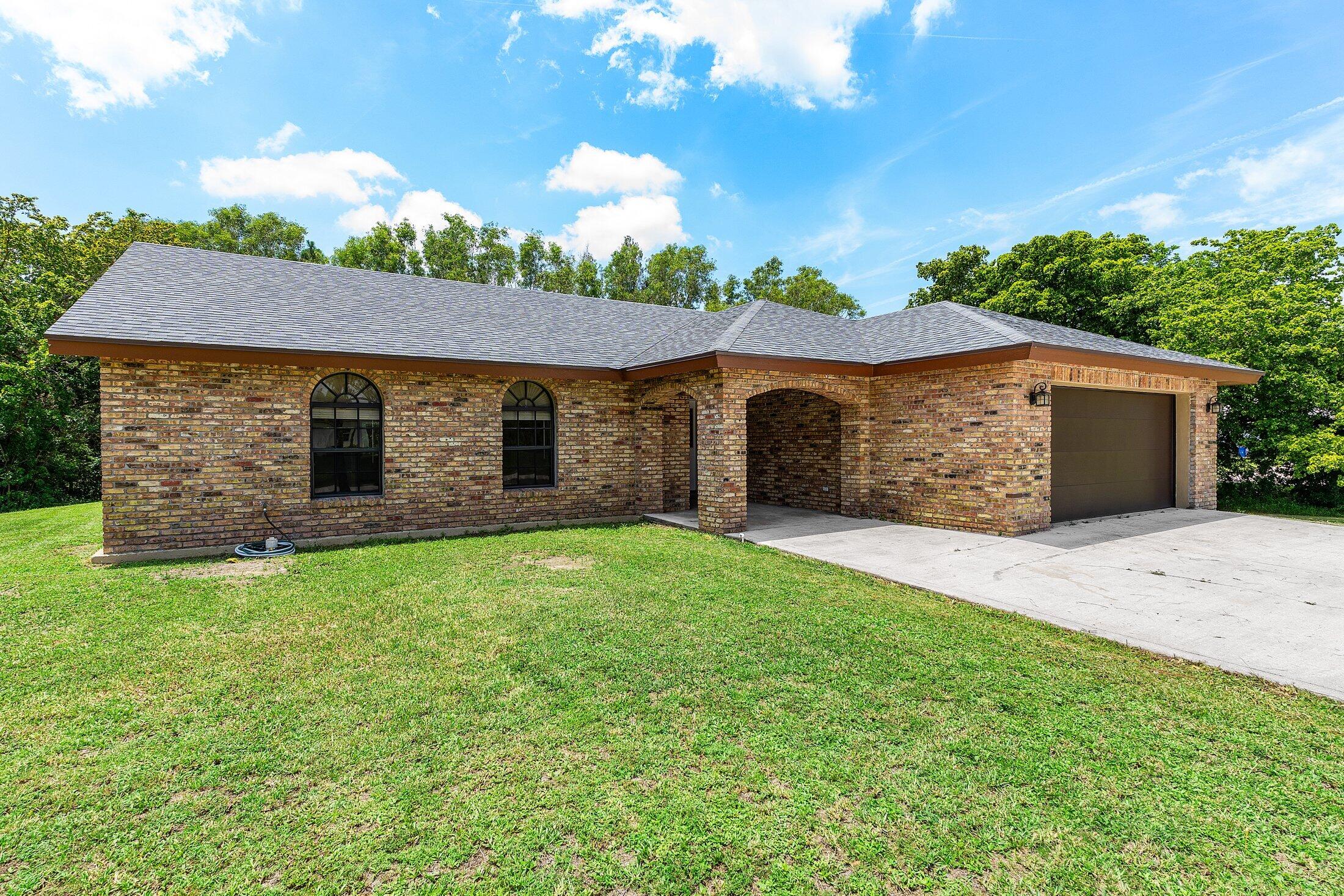 18142 43rd Road North Loxahatchee, FL 33470 - Photo 1 of 42 front view of a house with a yard