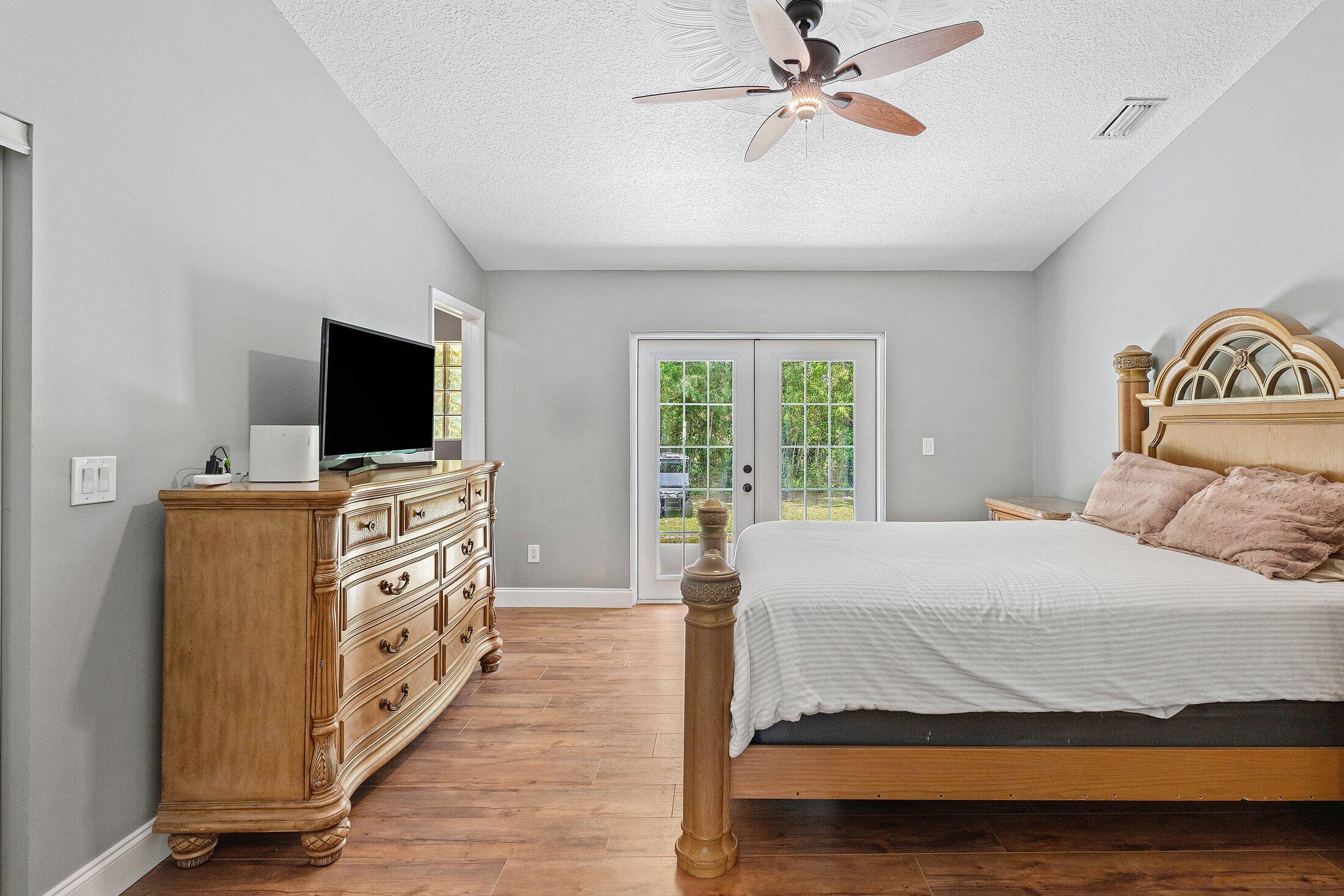 18142 43rd Road North Loxahatchee, FL 33470 - Photo 16 of 42 a bedroom with a bed and a flat screen tv