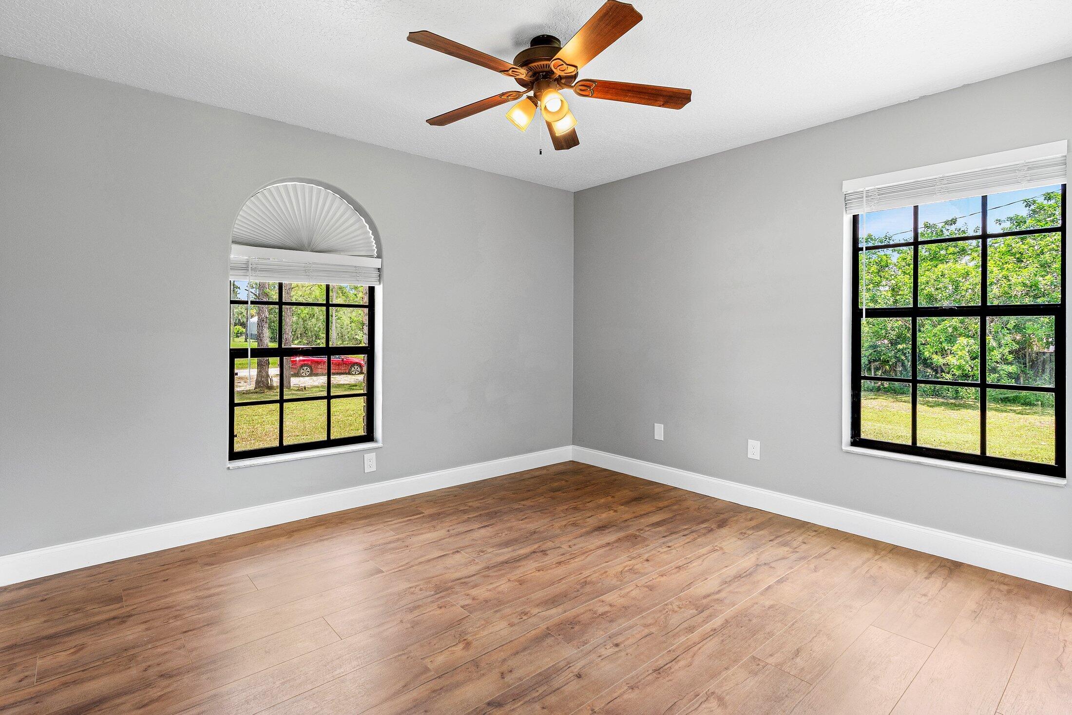 18142 43rd Road North Loxahatchee, FL 33470 - Photo 19 of 42 an empty room with windows and ceiling fan