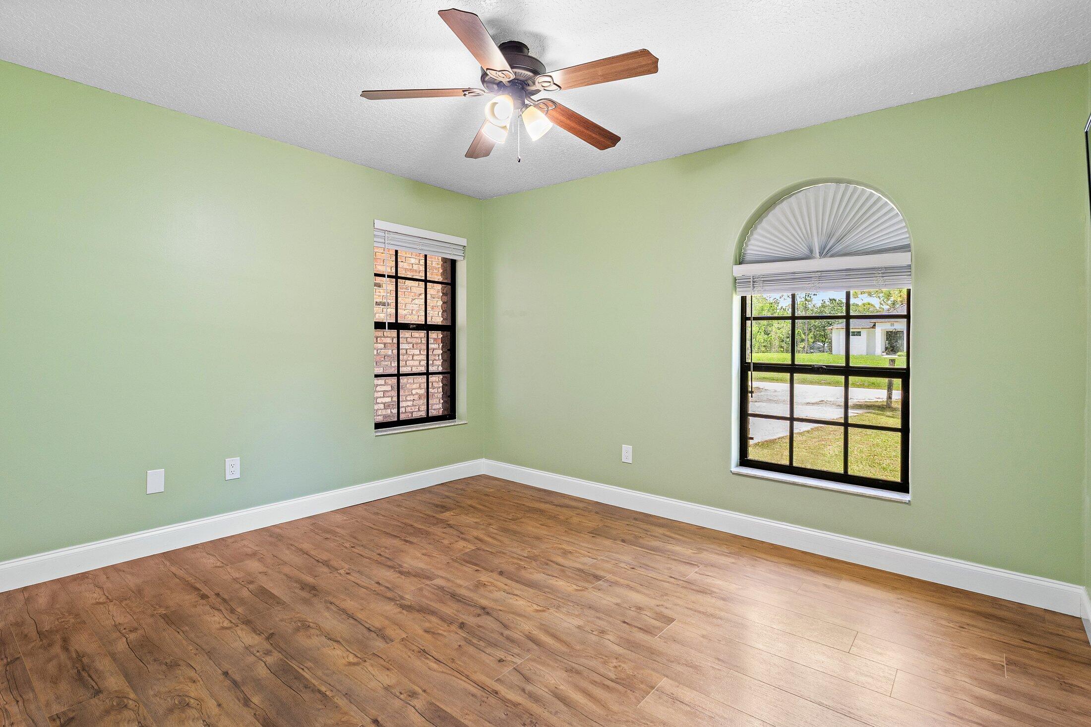 18142 43rd Road North Loxahatchee, FL 33470 - Photo 20 of 42 an empty room with windows and ceiling fan