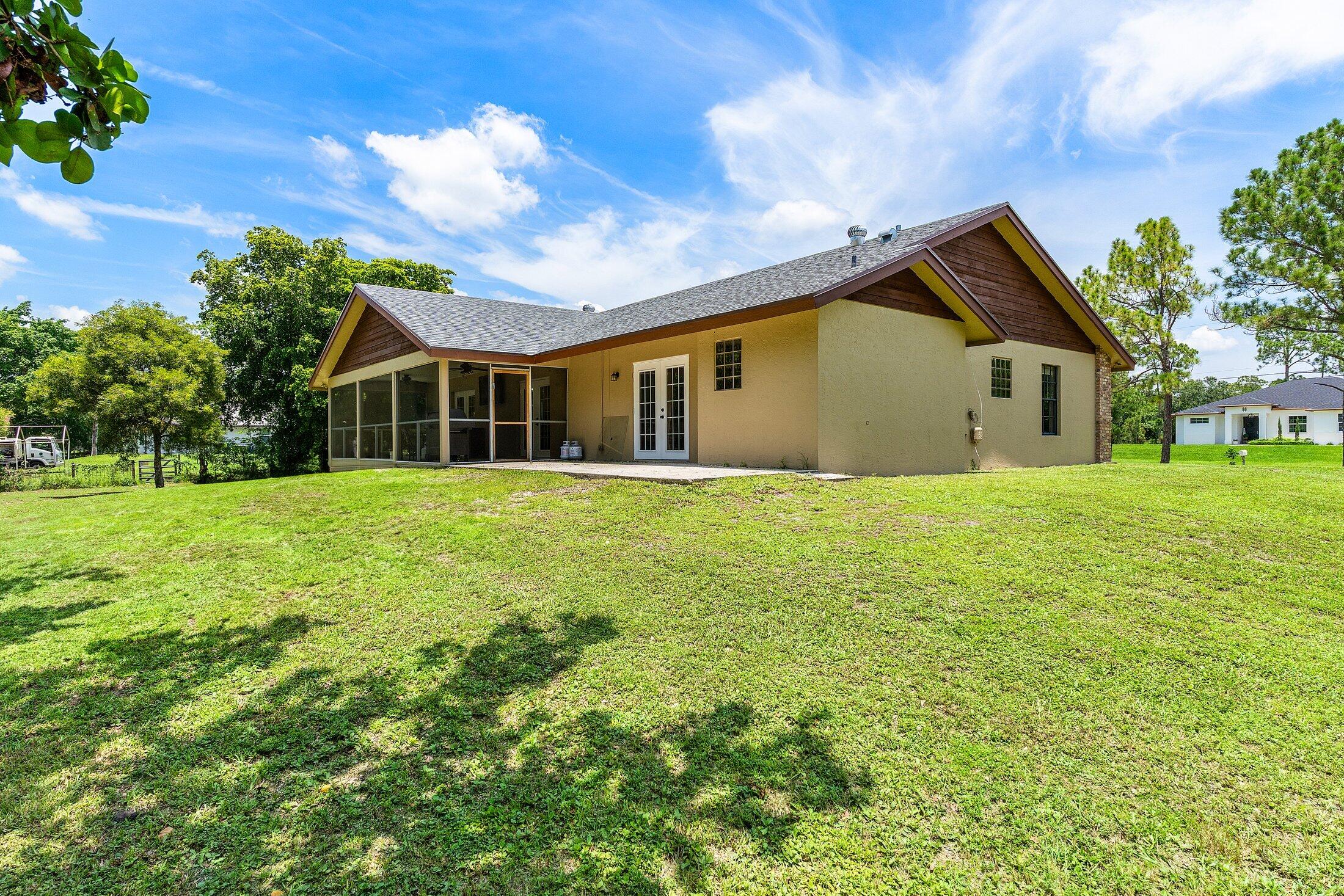 18142 43rd Road North Loxahatchee, FL 33470 - Photo 26 of 42 a front view of house with yard and green space