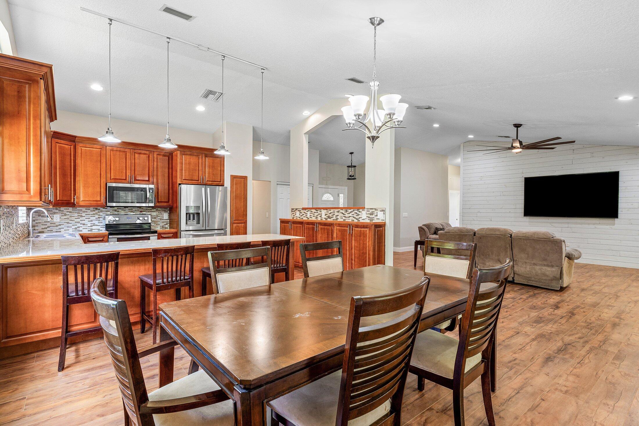 18142 43rd Road North Loxahatchee, FL 33470 - Photo 7 of 42 a view of a dining room with furniture a chandelier and wooden floor