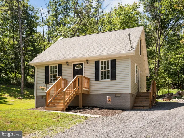 a view of a house with backyard and a tree