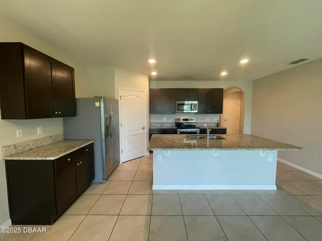 a kitchen with stainless steel appliances granite countertop a sink a stove a microwave and a refrigerator