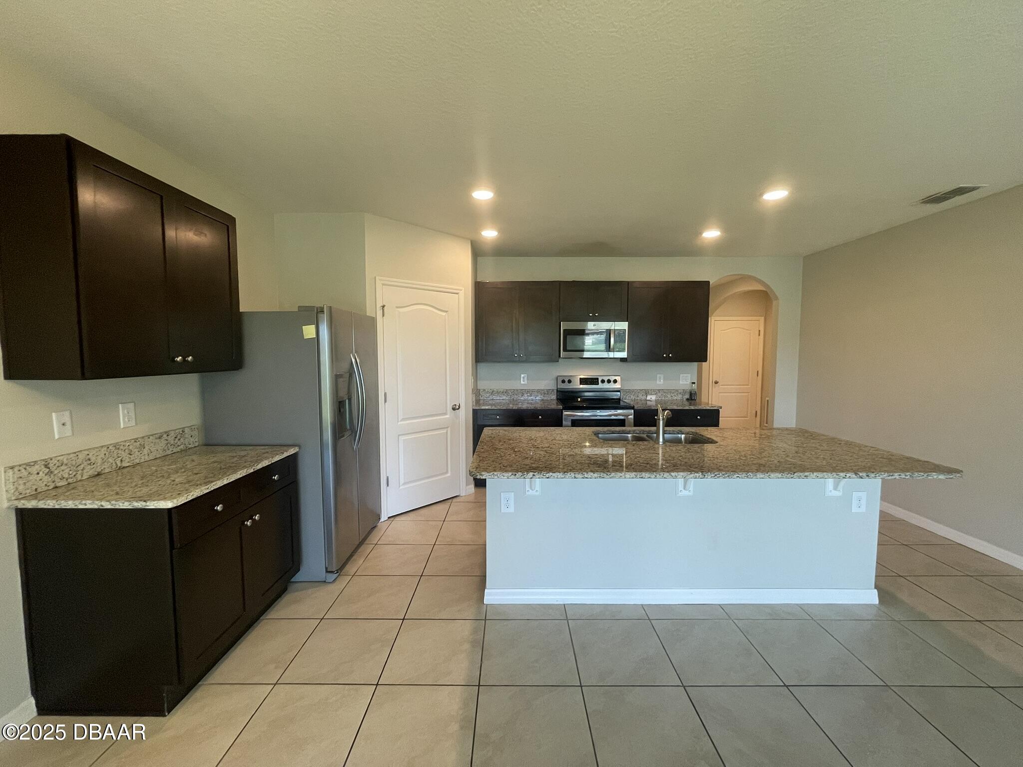 5343 Sandpine Haven Lane Port Orange, FL 32128 - Photo 2 of 44 a kitchen with stainless steel appliances granite countertop a sink a stove a microwave and a refrigerator