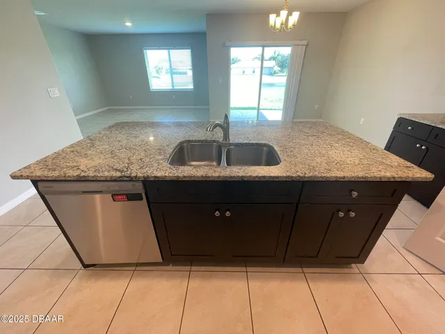 a kitchen with granite countertop a sink a counter top space and cabinets