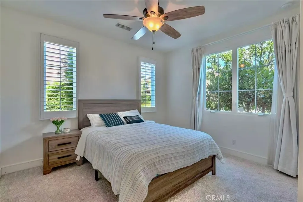 141 Dolci Irvine, CA 92606 - Photo 1 of 13 a bedroom with a bed a chandelier and a window