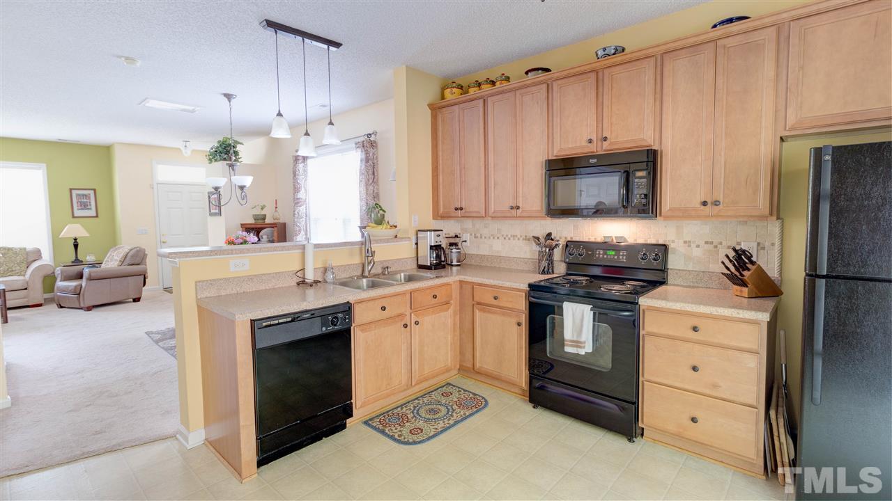 1011 Dual Parks Road Apex, NC 27502 - Photo 5 of 21 Convenient kitchen with 42" upper cabinets, black appliances. Beautiful ceramic backsplash.