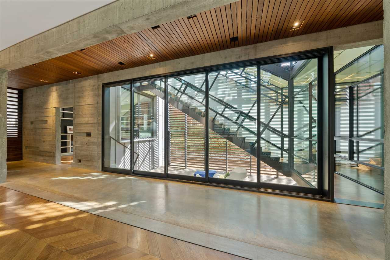 123 Hillcrest Road Raleigh, NC 27605 - Photo 9 of 30 the design of the home is like no other - as the hand build stair is enclosed with a sleeve of glass and steel, creating a stunning play of reflection and geometry the stair court
