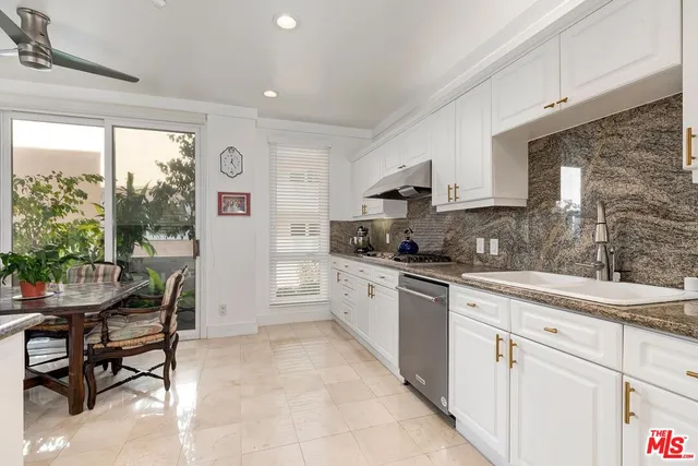 a kitchen with a sink window and cabinets