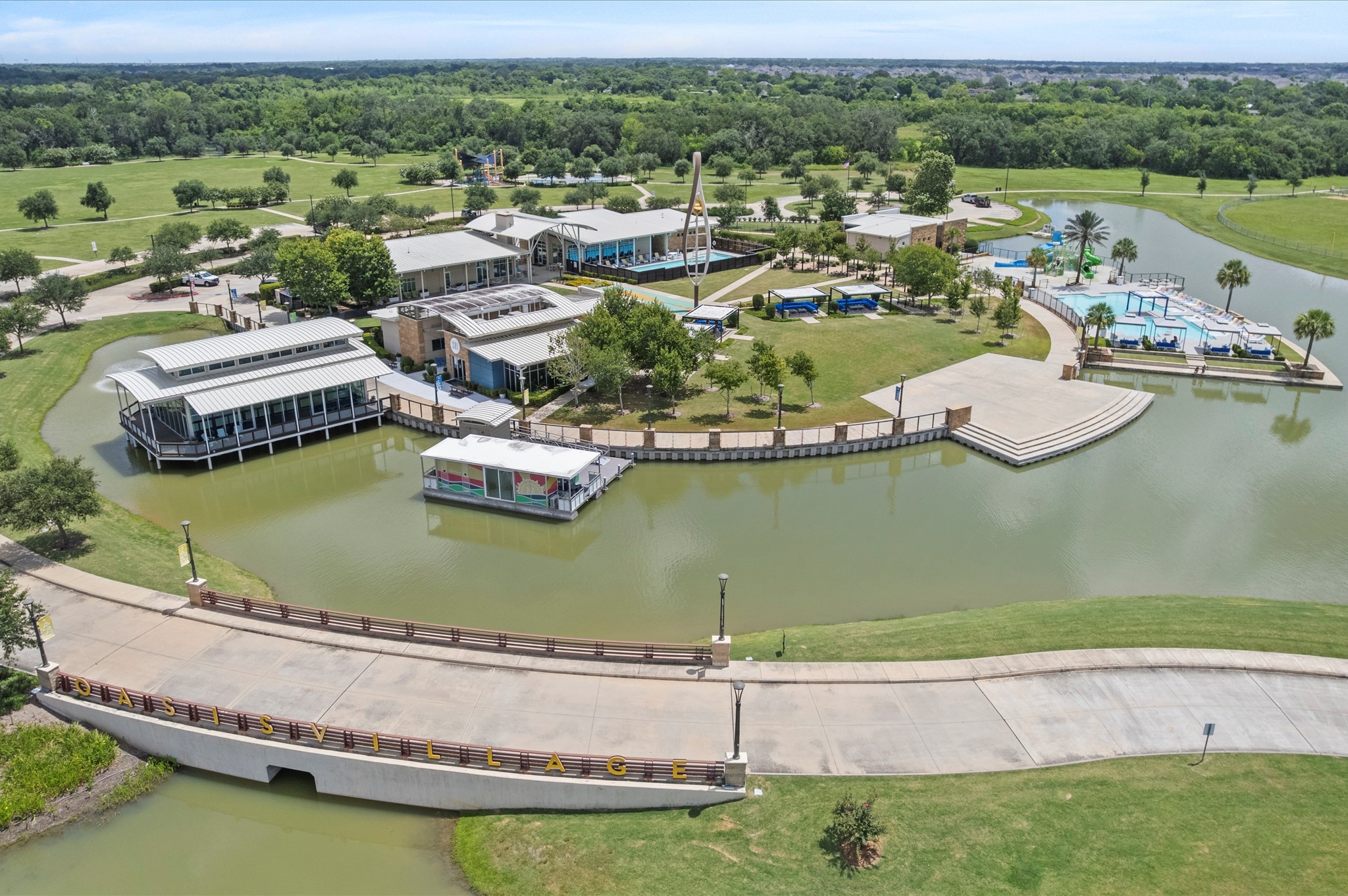 3510 Whitman Drive Rosharon, TX 77583 - Photo 21 of 25 This photo shows a serene residential area featuring a scenic waterway, modern pavilions, and lush green spaces, ideal for family activities and relaxation.
