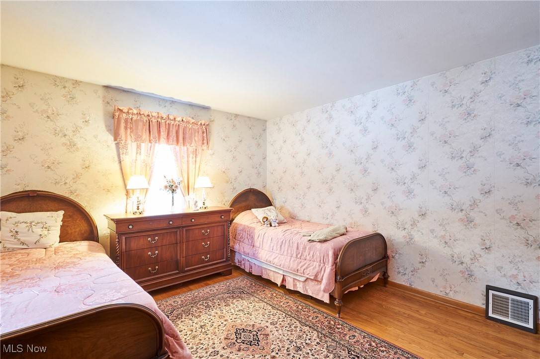 440 South Medina Line Road Akron, OH 44321 - Photo 9 of 27 Bedroom featuring wallpapered walls and wood finished floors