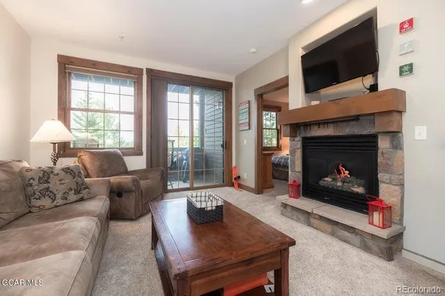 a living room with furniture a flat screen tv and a fireplace